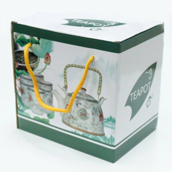 A cardboard box with a teapot illustration, green accents, the word "TEAPOT" printed on it, and yellow rope handles.